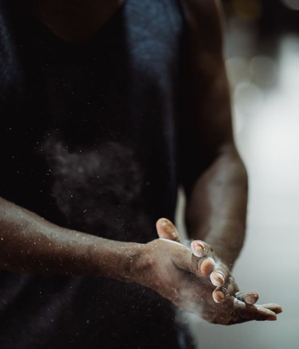 Athletic man performing strength exercise in a dark studio setting